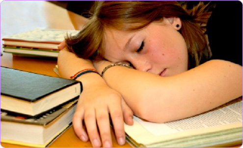 Adolescente dormido entre libros